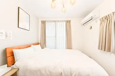 a bedroom with a white bed and a window at MaiMai Yahiro in Tokyo