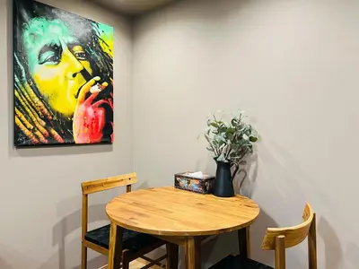 a table with a vase of flowers and a painting at Tokyo ShinjukStation 800meters kabukicho2minutes 403 in Tokyo
