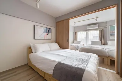 a bedroom with two beds and a window at Second Home SHIBUYA in Tokyo