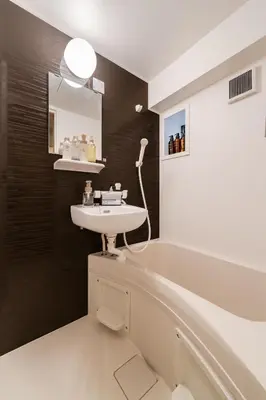 a bathroom with a sink and a mirror at Second Home SHIBUYA in Tokyo