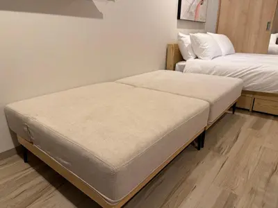 two beds sitting next to each other in a room at Second Home SHIBUYA in Tokyo