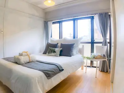 a bedroom with a bed with pillows and a window at 2BR 35m2 Bright Parkside Apt - JR 8 min Shinjuku in Tokyo