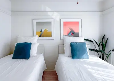 two white beds with blue pillows in a room at 2BR 35m2 Bright Parkside Apt - JR 8 min Shinjuku in Tokyo