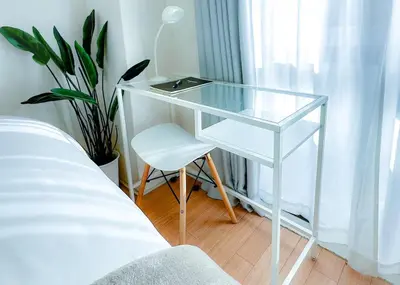 a glass desk with a chair next to a bed at 2BR 35m2 Bright Parkside Apt - JR 8 min Shinjuku in Tokyo