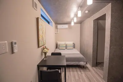 a small room with a bed and a desk and a table at \u4e0a\u91ce\u6d45\u8349\u30a8\u30ea\u30a2\u597d\u30a2\u30af\u30bb\u30b9 \u4ea4\u901a\u81f3\u4fbf \u89b3\u5149 \u30b7\u30e7\u30c3\u30d4\u30f3\u30b0 \u30b0\u30eb\u30e1\u306b\u6700\u9069\u306a\u6771\u4e0a\u91ce\u306e\u5bbf YoYh in Tokyo