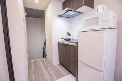 a small kitchen with a refrigerator and a sink at \u4e0a\u91ce\u6d45\u8349\u30a8\u30ea\u30a2\u597d\u30a2\u30af\u30bb\u30b9 \u4ea4\u901a\u81f3\u4fbf \u89b3\u5149 \u30b7\u30e7\u30c3\u30d4\u30f3\u30b0 \u30b0\u30eb\u30e1\u306b\u6700\u9069\u306a\u6771\u4e0a\u91ce\u306e\u5bbf YoYh in Tokyo
