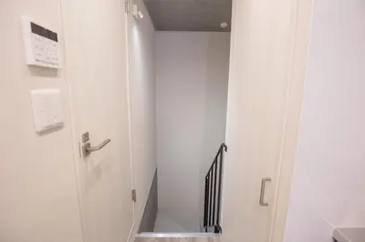 a hallway with a door and a stair case at \u4e0a\u91ce\u6d45\u8349\u30a8\u30ea\u30a2\u597d\u30a2\u30af\u30bb\u30b9 \u4ea4\u901a\u81f3\u4fbf \u89b3\u5149 \u30b7\u30e7\u30c3\u30d4\u30f3\u30b0 \u30b0\u30eb\u30e1\u306b\u6700\u9069\u306a\u6771\u4e0a\u91ce\u306e\u5bbf YoYh in Tokyo
