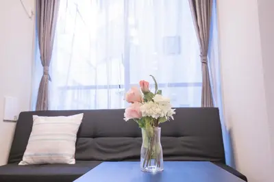 a vase of flowers on a table in front of a couch at \u4e0a\u91ce\u6d45\u8349\u30a8\u30ea\u30a2\u597d\u30a2\u30af\u30bb\u30b9 \u4ea4\u901a\u81f3\u4fbf \u89b3\u5149 \u30b7\u30e7\u30c3\u30d4\u30f3\u30b0 \u30b0\u30eb\u30e1\u306b\u6700\u9069\u306a\u6771\u4e0a\u91ce\u306e\u5bbf YoYh in Tokyo
