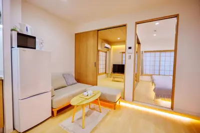 a small living room with a refrigerator and a table at M302 Hibiya Line Sannotsu Station 5 min by foot! First line direct to Ueno, Akihabara, Tsukiji Market, Ginza!Close to Asakusa Temple!! in Tokyo