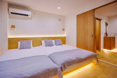 a bedroom with a large white bed with blue pillows at M302 Hibiya Line Sannotsu Station 5 min by foot! First line direct to Ueno, Akihabara, Tsukiji Market, Ginza!Close to Asakusa Temple!! in Tokyo