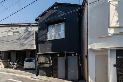 a black building with a window on the side of it at Direct access to major Tokyo stations including Shibuya, Shinjuku, Ikebukuro, Akihabara, and Ueno 3-minute walk from nearest station Tokyo Dome Suitable for long-term stays 101 in Tokyo