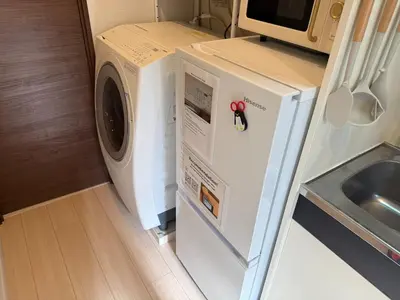 a washer and dryer in a kitchen next to a sink at Direct access to major Tokyo stations including Shibuya, Shinjuku, Ikebukuro, Akihabara, and Ueno 3-minute walk from nearest station Tokyo Dome Suitable for long-term stays 101 in Tokyo