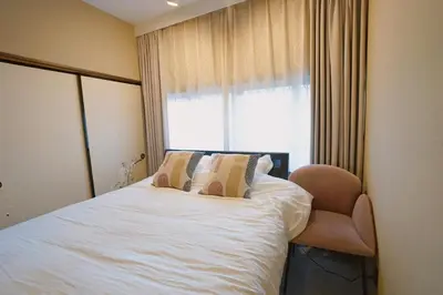 a bedroom with a bed with a chair and a window at 'OOGI House' Spacious Restored Traditional Machiya 53m2 with Tatami in Tokyo