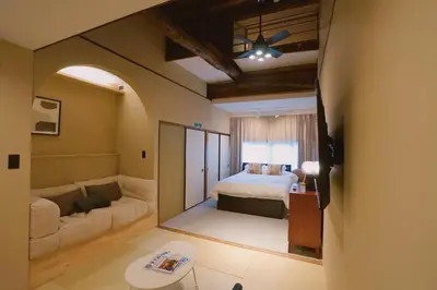 a bedroom with a bed and a living room at 'OOGI House' Spacious Restored Traditional Machiya 53m2 with Tatami in Tokyo