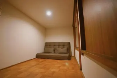 a room with a couch in the corner of a room at 'OOGI House' Spacious Restored Traditional Machiya 53m2 with Tatami in Tokyo