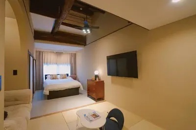 a bedroom with a bed and a flat screen tv at 'OOGI House' Spacious Restored Traditional Machiya 53m2 with Tatami in Tokyo