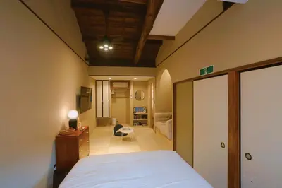 a bedroom with a bed and a desk and a room at 'OOGI House' Spacious Restored Traditional Machiya 53m2 with Tatami in Tokyo