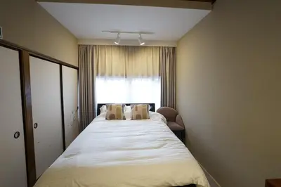 a bedroom with a large bed with a window at 'OOGI House' Spacious Restored Traditional Machiya 53m2 with Tatami in Tokyo