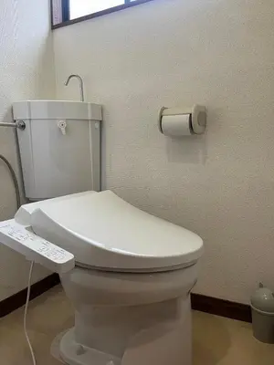 a white toilet in a bathroom with a remote control at Abeno house at Koenji in Tokyo