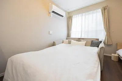 a bedroom with a white bed with a window at \u30ec\u30b8\u30c7\u30f3\u30b9\u30d1\u30fc\u30af\u6d45\u8349 in Tokyo