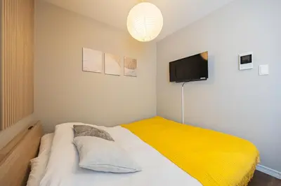 a bedroom with a bed with a yellow blanket at \u30ec\u30b8\u30c7\u30f3\u30b9\u30d1\u30fc\u30af\u6d45\u8349 in Tokyo