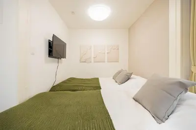 a bedroom with a bed with a television on the wall at \u30ec\u30b8\u30c7\u30f3\u30b9\u30d1\u30fc\u30af\u6d45\u8349 in Tokyo