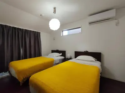 a room with two beds with yellow blankets at SunRiseStay Yahiro House\u516b\u5e83\u4e00\u6238\u5efa\u3066 in Tokyo