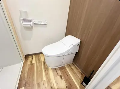 a white toilet in a bathroom with a wooden floor at Sunny Haven in Tokyo in Tokyo