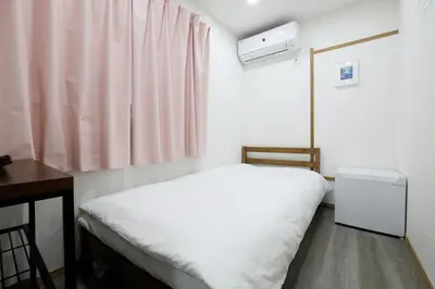 a small bedroom with a white bed and a desk at Tokyo My Home 1 in Tokyo