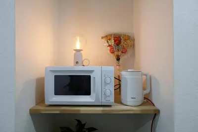 a microwave oven sitting on a table with a candle at Tokyo My Home 1 in Tokyo