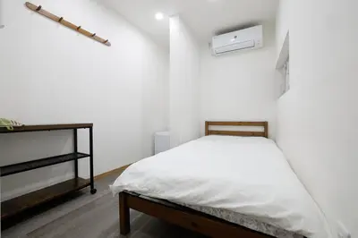 a small bedroom with a bed and a shelf at Tokyo My Home 1 in Tokyo