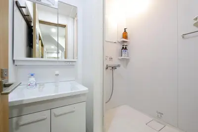 a white bathroom with a sink and a shower at Tokyo My Home 1 in Tokyo
