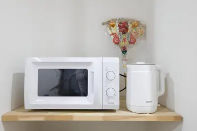 a microwave and a coffee maker on a shelf at Tokyo My Home 202 in Tokyo