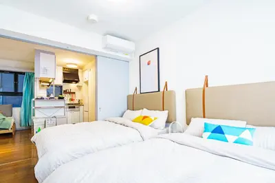 a room with three beds and a kitchen at Crest House in Tokyo