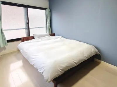a small bed in a room with a window at Yamatsu Tokyo House in Tokyo