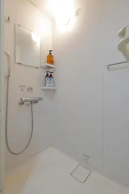a shower in a white bathroom with a mirror at Tokyo My Home 2 in Tokyo