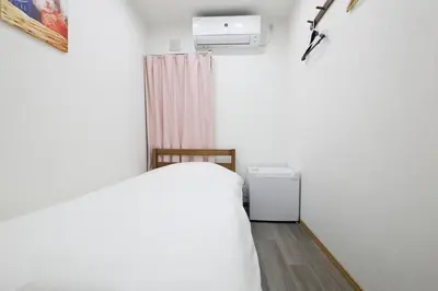 a bedroom with a white bed and a heater at 3 min from Shin-Okubo l Private Single Room 3 in Tokyo