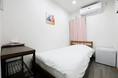 a bedroom with a white bed and a wooden table at 3 min from Shin-Okubo l Private Single Room 3 in Tokyo