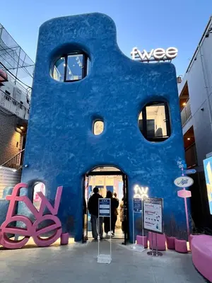 a blue building with people standing in the doorway at 3 min from Shin-Okubo l Private Single Room 3 in Tokyo