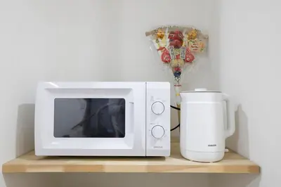 a microwave and a coffee maker on a shelf at 3 min from Shin-Okubo l Private Single Room 4 in Tokyo