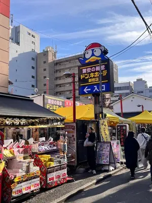 a person taking a picture of a food stand at 3 min from Shin-Okubo l Private Single Room 4 in Tokyo