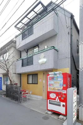 a red vending machine in front of a building at Tokyo My Home 201 in Tokyo