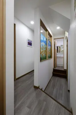a hallway with white walls and a painting on the wall at 3 min from Shin-Okubo l Private Single Room in Tokyo