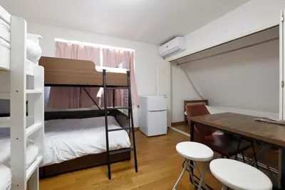 a room with a bunk bed and a table and chairs at 3 min from Shin-Okubo l Private Family Room for 5 in Tokyo