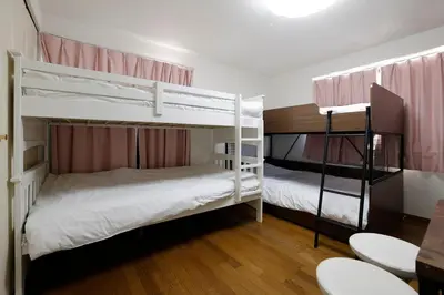 two bunk beds in a room with a table and chairs at 3 min from Shin-Okubo l Private Family Room for 5 in Tokyo