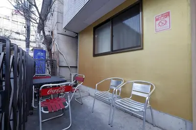 a group of chairs and a table in front of a building at 3 min from Shin-Okubo l Family Room for 4 in Tokyo