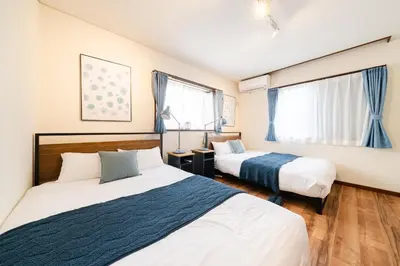a bedroom with two beds and two windows at HOTEL AndPlace ShinOkubo in Tokyo