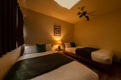 a bedroom with two beds and a ceiling fan at HOTEL AndPlace ShinOkubo in Tokyo