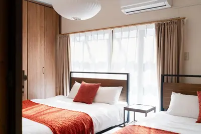 two beds in a room with a window at HOTEL AndPlace ShinOkubo in Tokyo