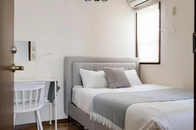 a bedroom with a bed and a table and a window at HOTEL AndPlace ShinOkubo in Tokyo
